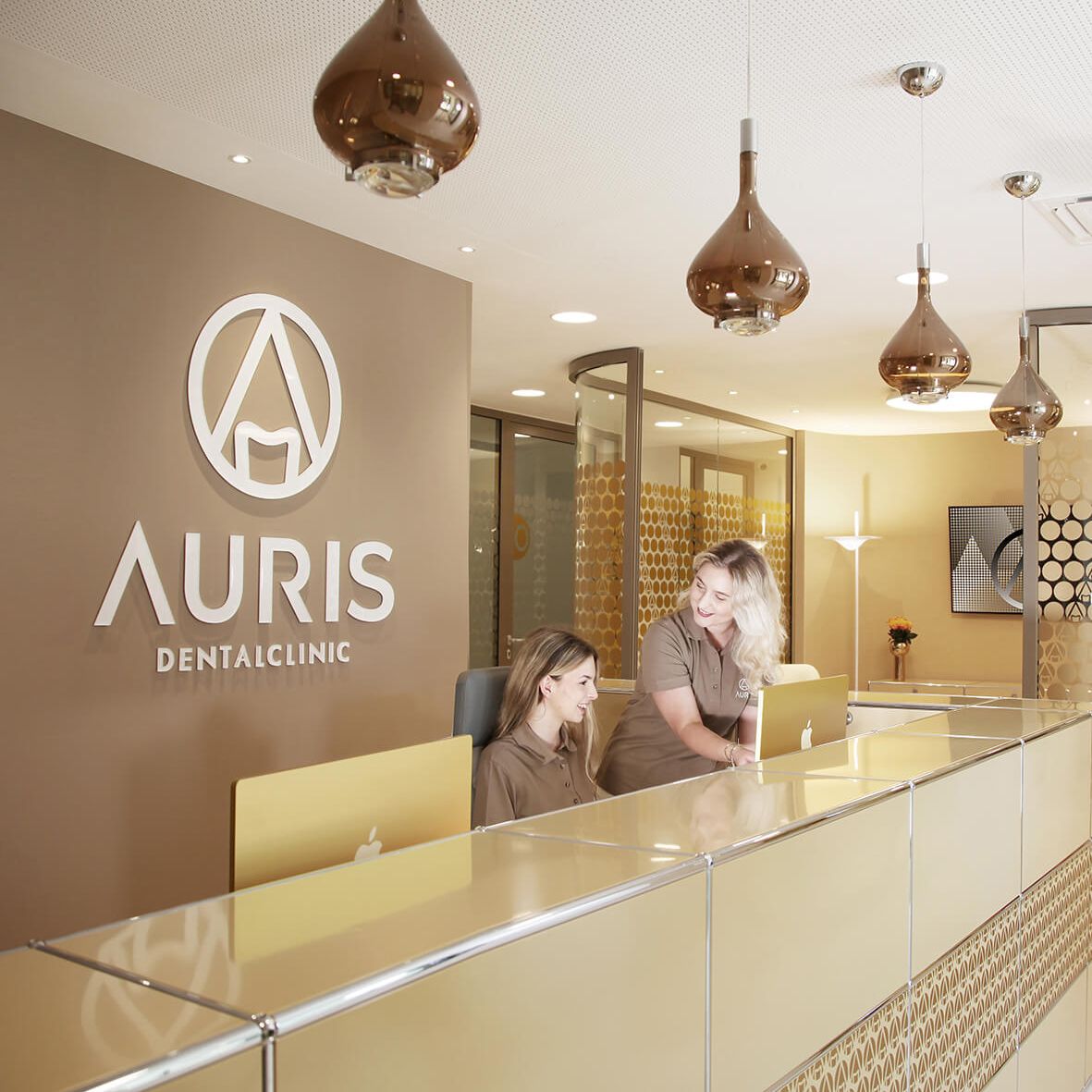 Empfangsbereich der Auris Dentalclinic mit goldener Wandgestaltung